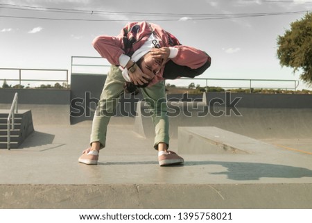 Young white dancer dancing hip-hop freestyle in a skate park