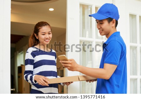 Delivery man accepting payment via mobile application after delivering pizza to female customer