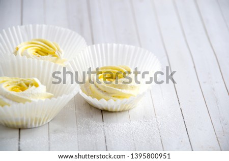 Lemon Meringue Marshmallow Zephyr and powdered sugar On Wooden Background.Top view. Place for text