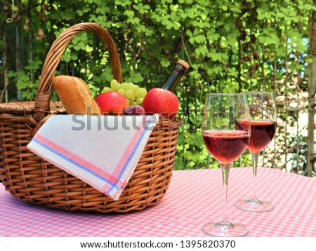 Pink napkin picnic basket and two glasses of wine.
Two glasses and a bottle of wine. Picnic in the park. Good weekend. Spring