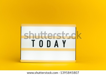 Photo of a light box with text, TODAY, on isolated yellow background