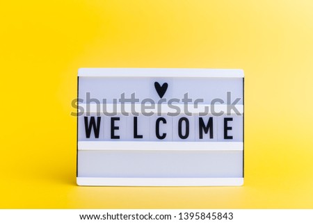 Photo of a light box with text, WELCOME, on isolated yellow background