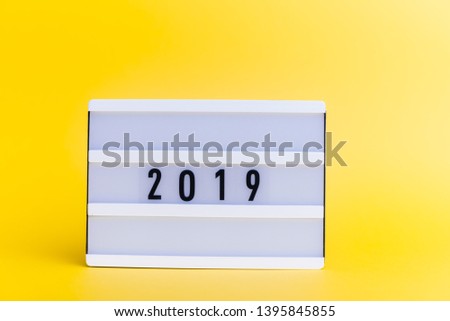 Photo of a light box with text, 2019, on isolated yellow background