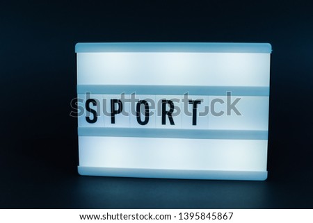 Photo of a light box with text, SPORT, over isolated dark background