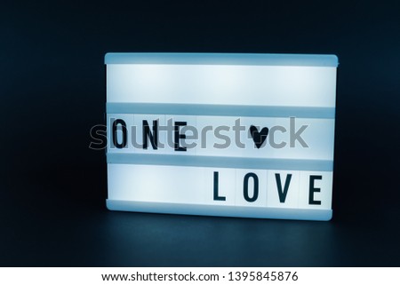 Photo of a light box with text, ONE LOVE, over  isolated dark background