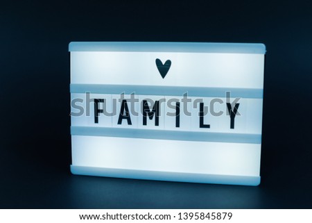Photo of a light box with text, FAMILY, over  isolated dark background