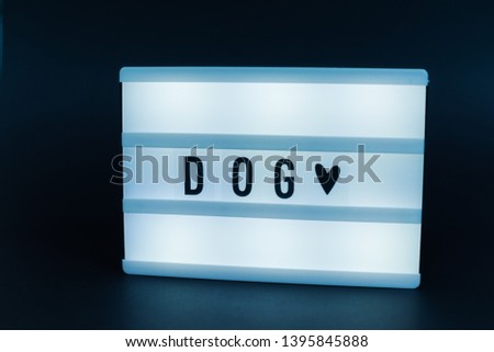 Photo of a light box with text, DOG, over isolated dark background