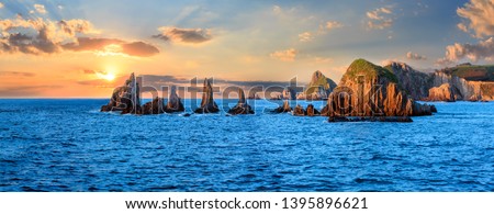 Sharp islets near Gueirua beach, Asturias, Spain. Sunset evening beautiful Atlantic ocean landscape. Multi shots high-resolution stitch panorama. Royalty-Free Stock Photo #1395896621