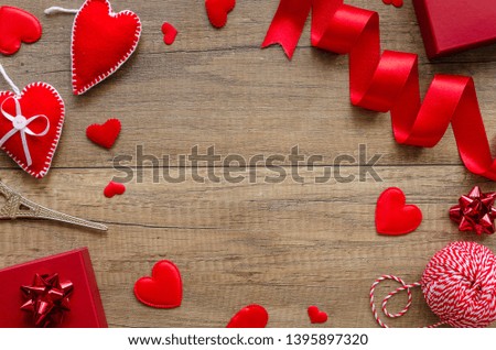 Flat lay romantic card concept. Border arrangement with hearts, red ring box on a wooden background. Copy space for text in the middle