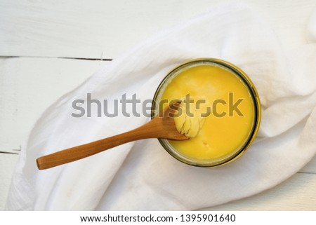 Ghee butter or clarified butter on a table with wooden spoon, top view Royalty-Free Stock Photo #1395901640