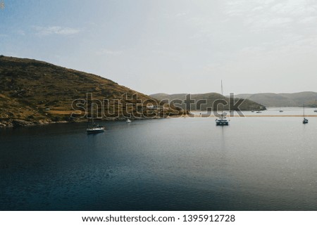 Aerial view of yachts and catamarans in the sea near the islands. Boats and yachts in the bay are anchored. Sailing in Greece, the Aegean Sea. Beautiful view of the sea and the beaches of the islands