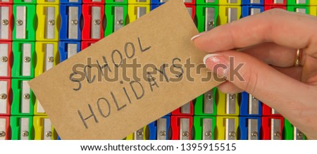 The concept of holidays in school. The inscription school holidays on the background of multi-colored pencil sharpeners, close-up, with space for the text. Banner