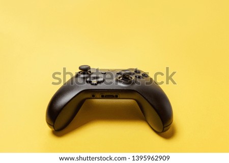 Black joystick gamepad, game console on yellow colourful trendy modern fashion pin-up background. Computer gaming competition videogame control confrontation concept. Cyberspace symbol