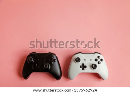 White and black two joystick gamepad, game console on pastel pink colourful trendy pin-up background. Computer gaming competition videogame control confrontation concept. Cyberspace symbol