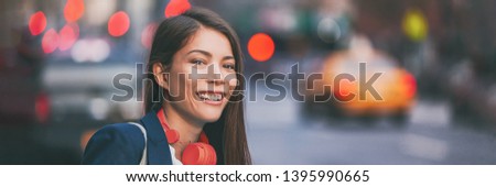 People city lifestyle young happy Asian woman walking in New York City street urban background with red headphones. Panoramic banner header.