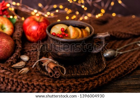 Autumn, fall leaves, hot cup of tea, knitted blanket on vintage wooden table background. Seasonal, autumnal hot drink. Autumn relaxing and still life concept. Toned image. Selective focus.
