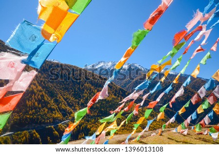 Colorful tibetan flags and snow mountain at Siguniang scenic area in autumn season,chengdu, China.