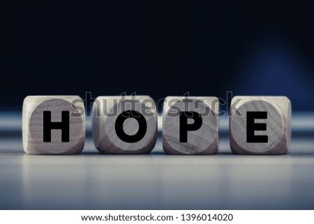 Four wooden blocks with Hope text of concept.