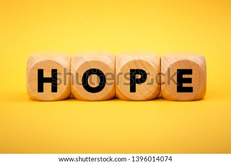 Four wooden blocks with Hope text of concept.