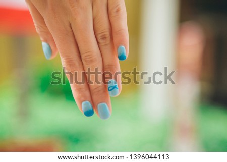 macro: blue manicure with a pattern of fish on the woman's hand. Picture Christian symbol varnish