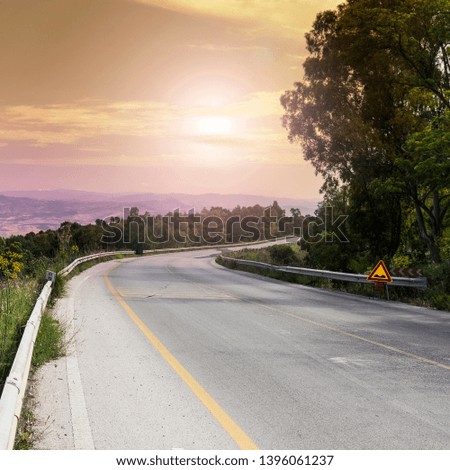 Landscape of Sicilian hills at sunrise. Asphalt road elevated by columns due of frequent earthquakes of the island of Sicily