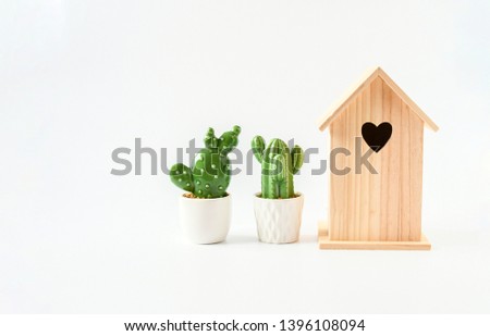 Objects, nature wood small house and small cearamic cactus green plant and white pot put on white background isolated, idea home decorate or home finance concept.