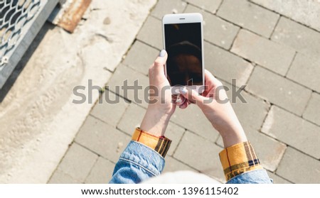 Female hands holding a smartphone with a blank screen