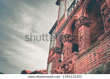 Photo depicts a mansion with a cloudy sky.