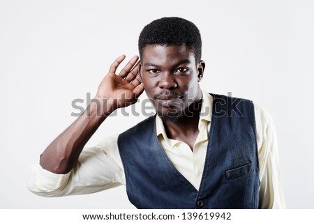 African American holds his hand near his ear and listening something