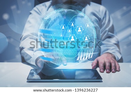 Man at office table using tablet computer with social connection hologram and infographics. Concept of people network in business and global world. Toned image double exposure