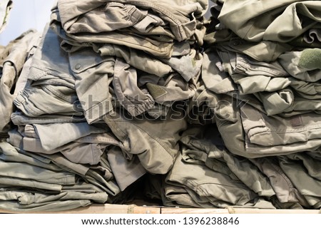 green camouflage surplus of military clothes in the store for sale 
