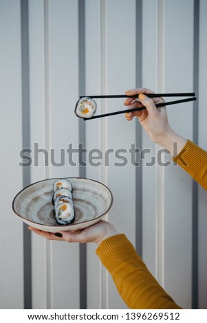 Crop picture girl eating sushi 