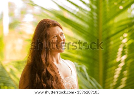 lifestyle fresh and natural portrait of young beautiful and happy red hair woman smiling cheerful and carefree enjoying Summer holidays trip in tropical island isolated on jungle background