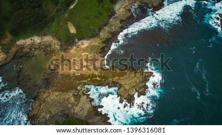 Watulumbung beach aerial photography top view with water wave splash along shoreline