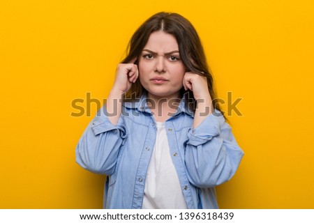 Young curvy plus size woman focused on a task, keeping him forefingers pointing head.