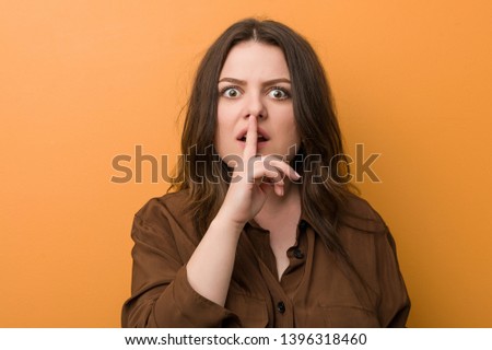 Young curvy russian woman keeping a secret or asking for silence.