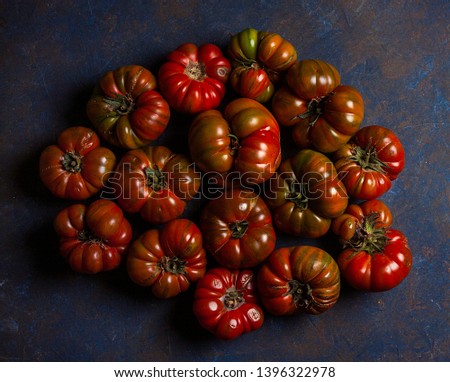 TOMATOES GROUPED ON DARK BACKGROUND WITH TEXTURE