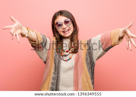 Little hippie girl feels confident giving a hug to the camera.