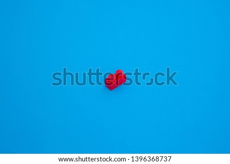 red plastic block on blue paper background . object in the middle and many space for text . isometric business concept .