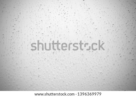Water drops on glass, white gray black background.