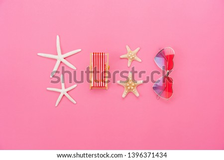 Flat lay image of essential accessories in summer holiday background concept.Sun glasses & Beach table with starfish in vacation season.Table top view several objects sign on pink paper wallpaper.