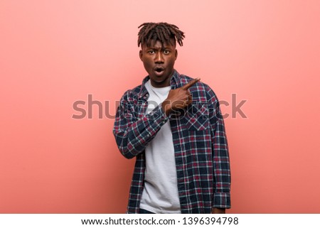 Young african black man pointing to the side