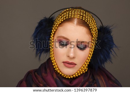 Creative portrait of an interesting woman in an unusual style using chaplet. Studio photo session. Gray background