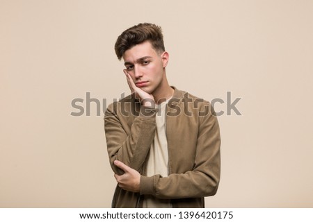 Young caucasian man wearing a brown jacket who is bored, fatigued and need a relax day.