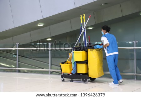 Closeup of woman cleaning worker doing her work with janitorial, cleaning equipment and tools for floor cleaning at the airport. Royalty-Free Stock Photo #1396426379