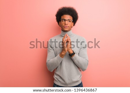 Young african american man over a pink wall devising a plan