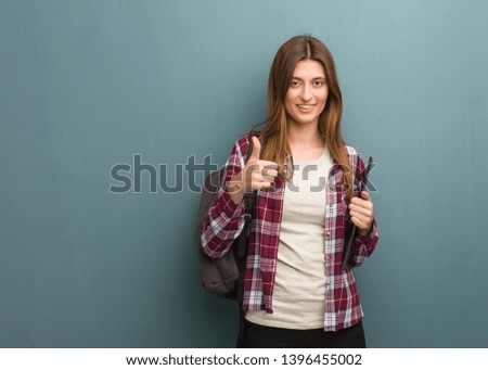 Young student russian woman smiling and raising thumb up