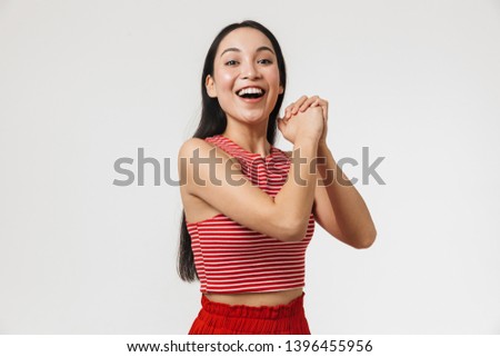 Picture of a beautiful excited happy young pretty asian woman posing isolated over white wall background.