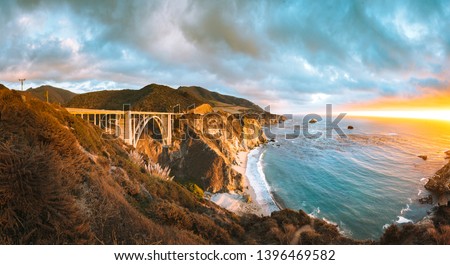 Scenic panoramic view of historic Bixby Creek Bridge along world famous Highway 1 in beautiful golden evening light at sunset with dramatic cloudscape in summer, Monterey County, California, USA Royalty-Free Stock Photo #1396469582