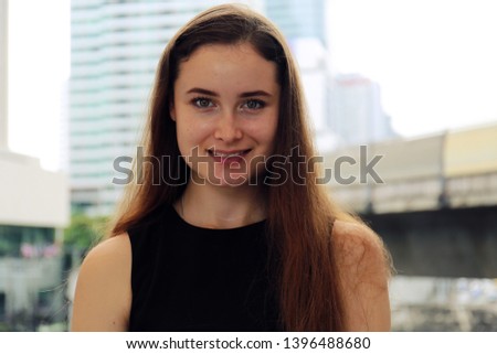 Close-up Beautiful woman smile portrait and office building background.	
